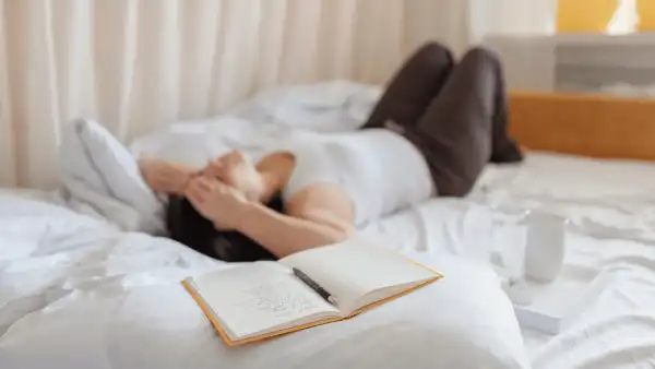 a woman struggling with insomnia laying down on a bed