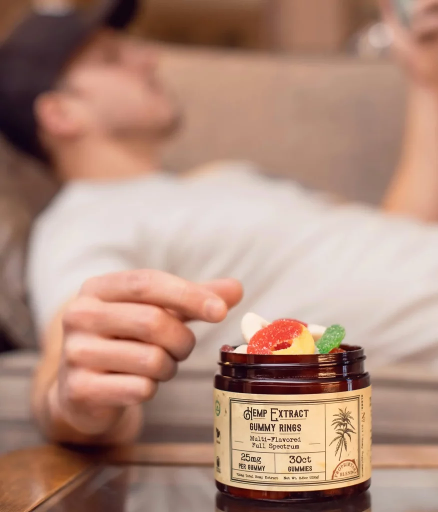 man picking gummies from jar