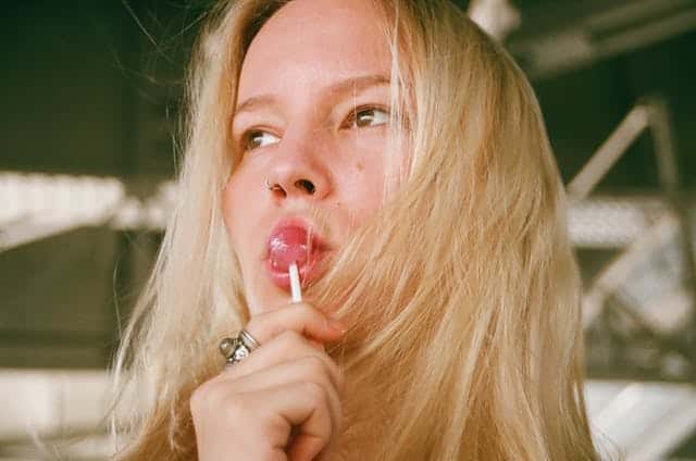 A woman sucking on a lollipop